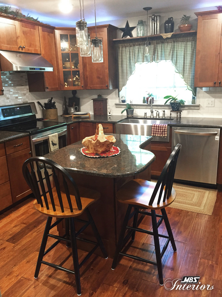 Foto på ett mellanstort vintage kök, med en rustik diskho, skåp i shakerstil, skåp i mellenmörkt trä, granitbänkskiva, vitt stänkskydd, stänkskydd i tunnelbanekakel, rostfria vitvaror, mellanmörkt trägolv och en köksö