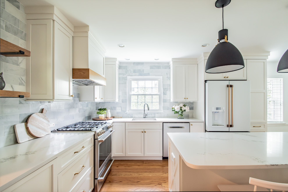 Idéer för ett mellanstort klassiskt vit kök, med en undermonterad diskho, släta luckor, vita skåp, bänkskiva i kvartsit, grått stänkskydd, stänkskydd i marmor, färgglada vitvaror, mellanmörkt trägolv, en köksö och brunt golv
