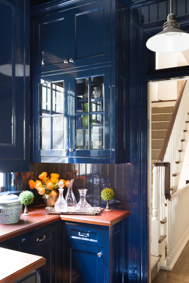 Inspiration for a mid-sized transitional u-shaped medium tone wood floor kitchen pantry remodel in San Francisco with glass-front cabinets, blue cabinets, blue backsplash, no island and a drop-in sink