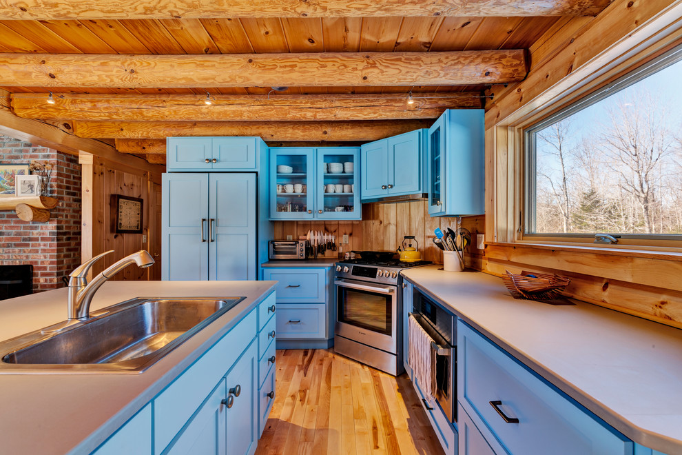 Design ideas for a medium sized rustic l-shaped open plan kitchen in Burlington with shaker cabinets, blue cabinets, composite countertops, an island and grey worktops.