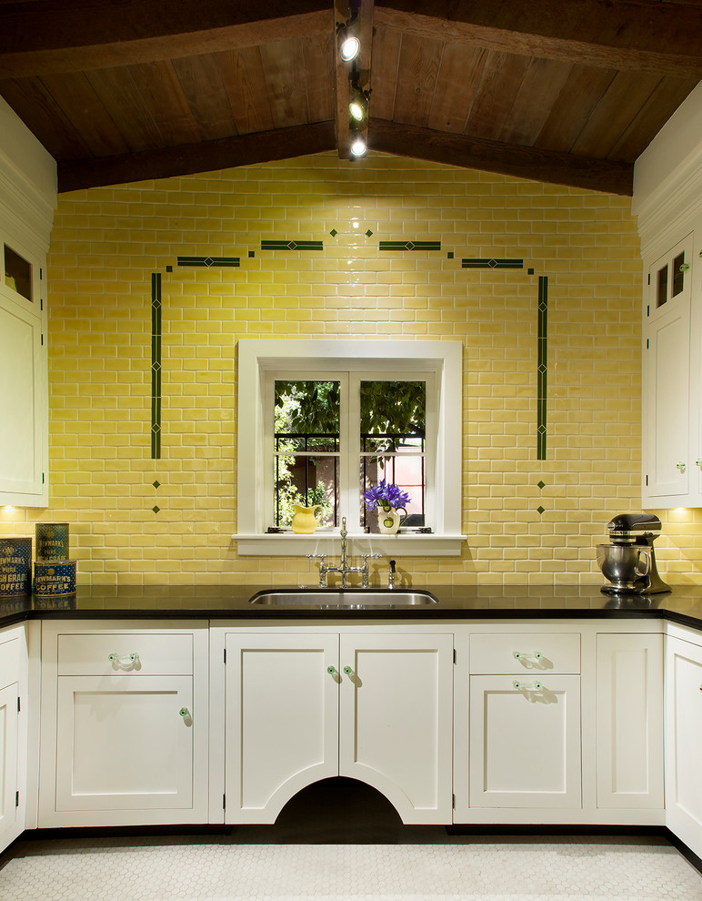 Inspiration för avskilda klassiska u-kök, med en dubbel diskho, luckor med profilerade fronter, vita skåp, granitbänkskiva, gult stänkskydd, stänkskydd i keramik, svarta vitvaror och klinkergolv i keramik
