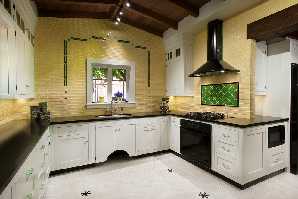 Bild på ett avskilt, mellanstort vintage u-kök, med en dubbel diskho, luckor med profilerade fronter, vita skåp, granitbänkskiva, gult stänkskydd, stänkskydd i keramik, svarta vitvaror och klinkergolv i keramik