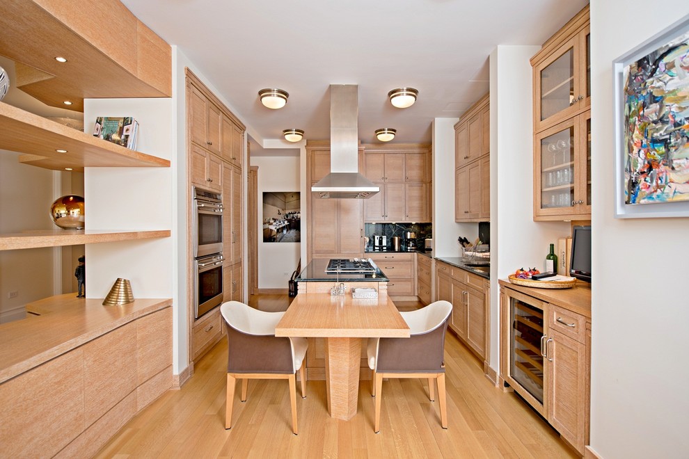 Moderne Wohnküche in U-Form mit Unterbauwaschbecken, Schrankfronten im Shaker-Stil, hellbraunen Holzschränken, Küchenrückwand in Schwarz und Küchengeräten aus Edelstahl in New York