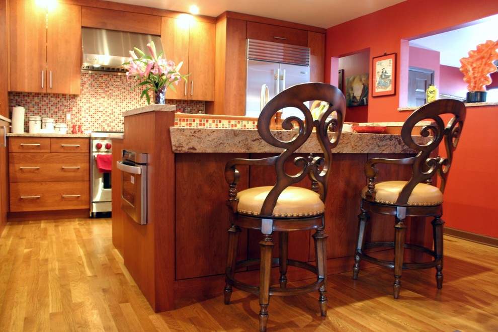 На фото: кухня в современном стиле с обеденным столом, врезной мойкой, плоскими фасадами, фасадами цвета дерева среднего тона, гранитной столешницей, разноцветным фартуком и техникой из нержавеющей стали