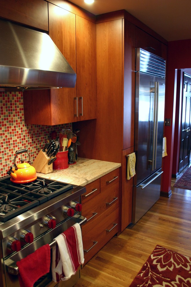 This is an example of a contemporary kitchen/diner in Denver with a submerged sink, flat-panel cabinets, medium wood cabinets, granite worktops, multi-coloured splashback and stainless steel appliances.