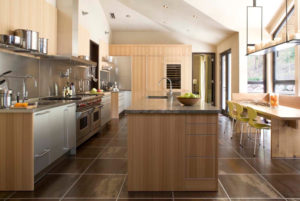 Expansive contemporary galley kitchen/diner in Denver with a submerged sink, flat-panel cabinets, light wood cabinets, metallic splashback, stainless steel appliances, an island and stainless steel worktops.