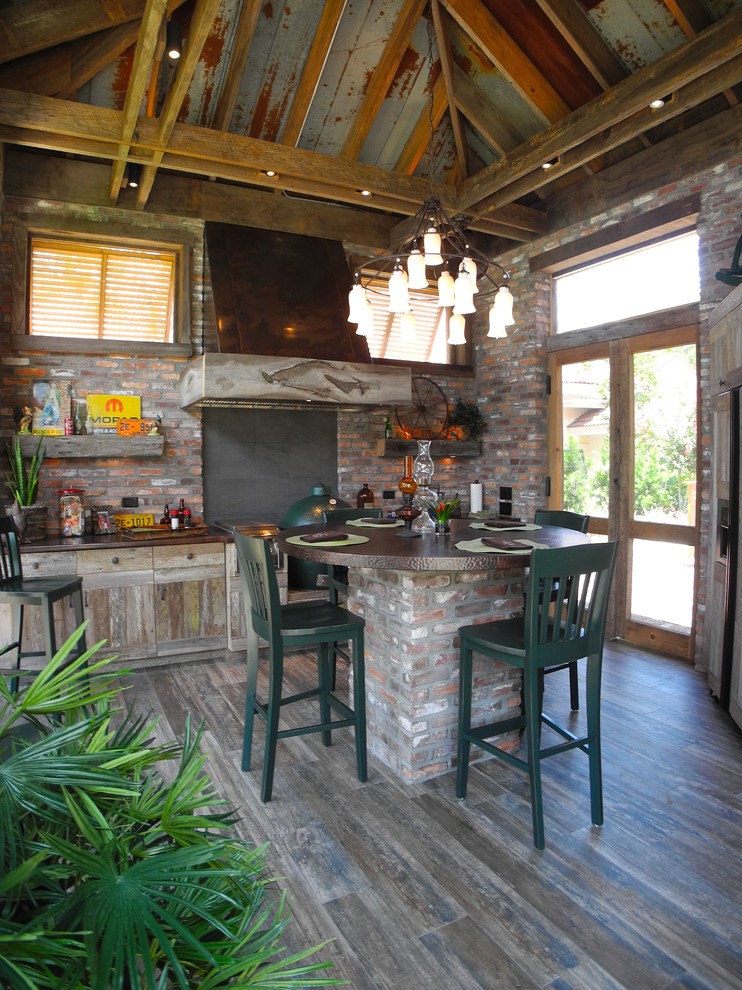Cette photo montre une grande cuisine américaine montagne en bois vieilli avec un placard à porte plane, un plan de travail en cuivre et un sol en carrelage de porcelaine.