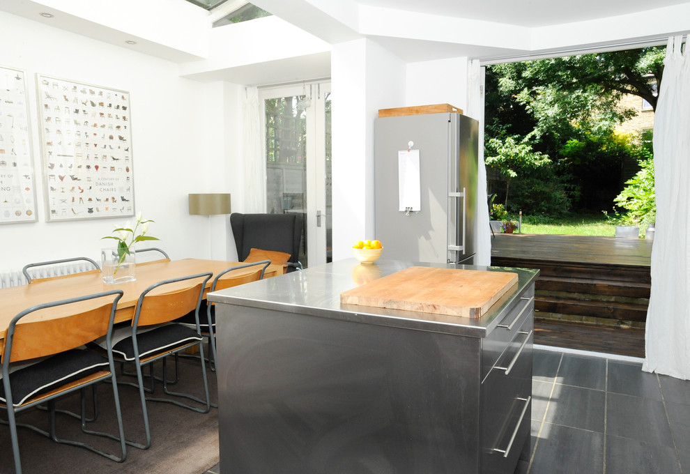 Photo of a contemporary kitchen in London with flat-panel cabinets, stainless steel cabinets, stainless steel worktops and stainless steel appliances.