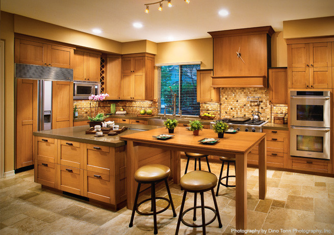 Inspiration for a large craftsman l-shaped eat-in kitchen remodel in Seattle with a farmhouse sink, shaker cabinets, medium tone wood cabinets, quartzite countertops, brown backsplash, ceramic backsplash, stainless steel appliances and an island