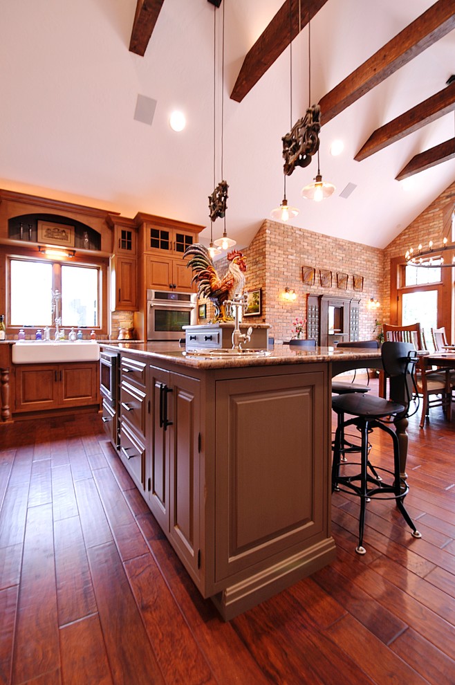 Foto på ett amerikanskt kök och matrum, med en rustik diskho, skåp i mellenmörkt trä, granitbänkskiva, rostfria vitvaror och en köksö