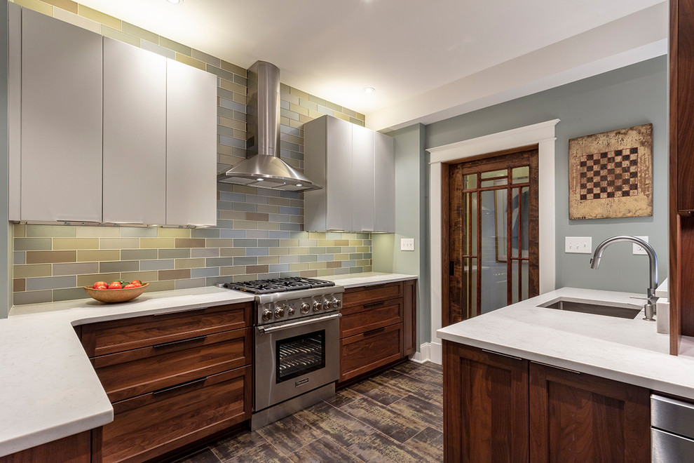 Example of a small transitional l-shaped porcelain tile and brown floor enclosed kitchen design in Other with an undermount sink, shaker cabinets, medium tone wood cabinets, quartz countertops, metallic backsplash, glass tile backsplash, stainless steel appliances, a peninsula and white countertops