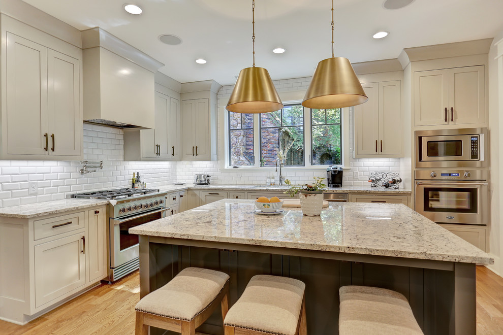 Mid-sized transitional l-shaped light wood floor and beige floor open concept kitchen photo in Other with an undermount sink, shaker cabinets, gray cabinets, granite countertops, white backsplash, subway tile backsplash, stainless steel appliances, an island and gray countertops