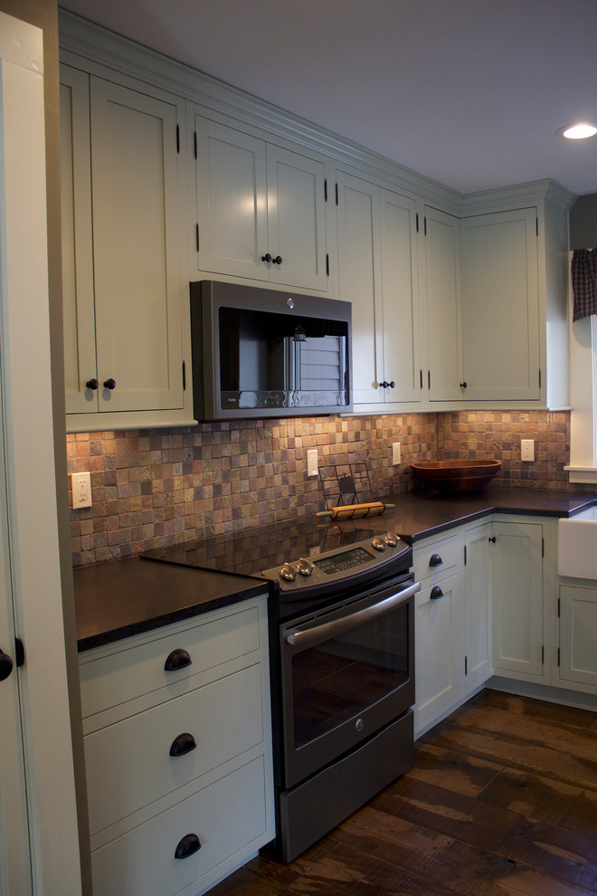 Idéer för att renovera ett mellanstort amerikanskt svart svart kök, med en rustik diskho, skåp i shakerstil, gröna skåp, granitbänkskiva, flerfärgad stänkskydd, stänkskydd i skiffer, svarta vitvaror, mellanmörkt trägolv och brunt golv