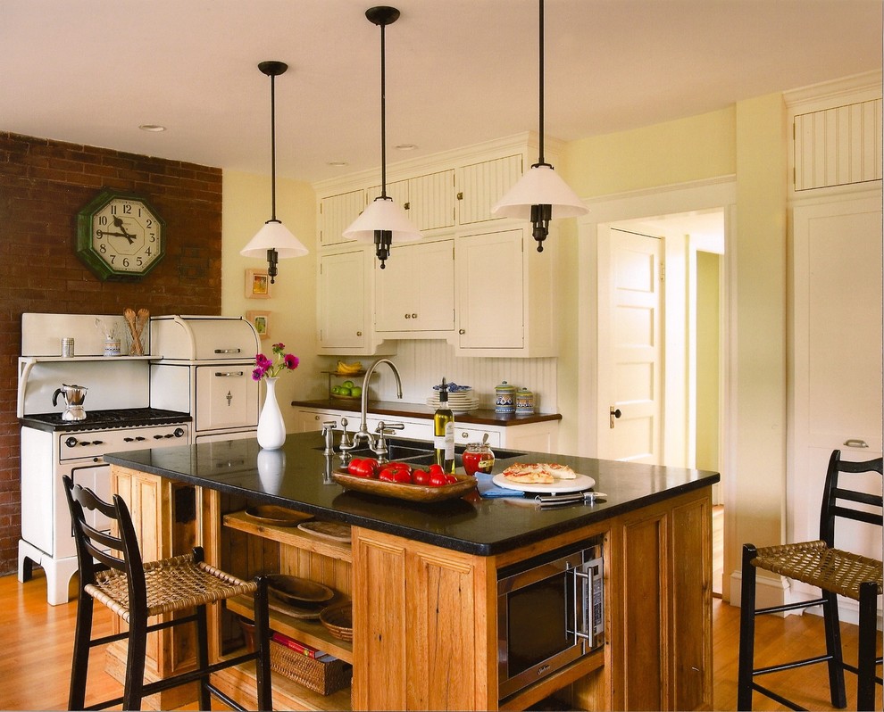 Inspiration for a mid-sized craftsman l-shaped light wood floor eat-in kitchen remodel in Boston with a double-bowl sink, shaker cabinets, granite countertops, white appliances, an island, light wood cabinets, white backsplash and wood backsplash