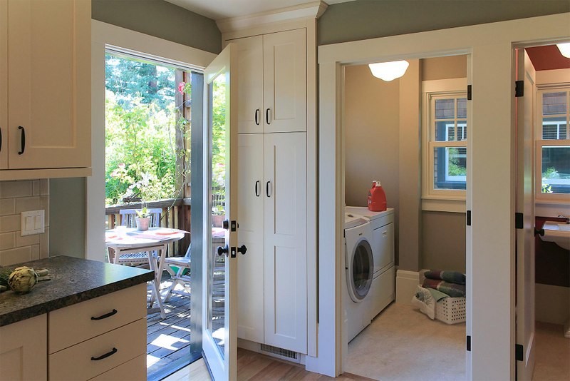 Example of a mid-sized arts and crafts l-shaped light wood floor enclosed kitchen design in San Francisco with an undermount sink, shaker cabinets, white cabinets, granite countertops, white backsplash, subway tile backsplash, stainless steel appliances and no island