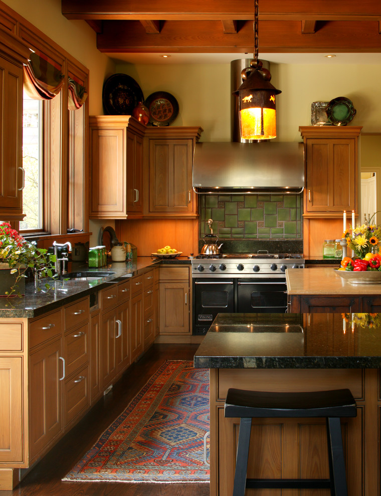 Example of a large arts and crafts l-shaped medium tone wood floor and brown floor kitchen pantry design in Detroit with an undermount sink, recessed-panel cabinets, medium tone wood cabinets, granite countertops, yellow backsplash, ceramic backsplash, stainless steel appliances, an island and black countertops