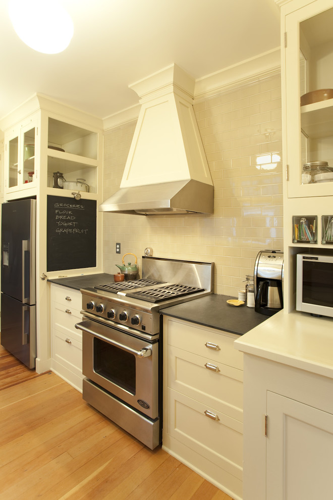ポートランドにあるトラディショナルスタイルのおしゃれなキッチン (落し込みパネル扉のキャビネット、シルバーの調理設備、白いキャビネット、白いキッチンパネル、サブウェイタイルのキッチンパネル) の写真