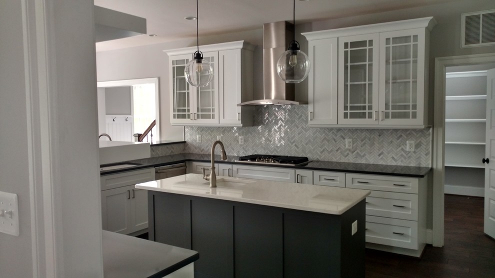 Medium sized traditional u-shaped enclosed kitchen in DC Metro with a submerged sink, glass-front cabinets, white cabinets, engineered stone countertops, grey splashback, porcelain splashback, stainless steel appliances, dark hardwood flooring, an island and black floors.
