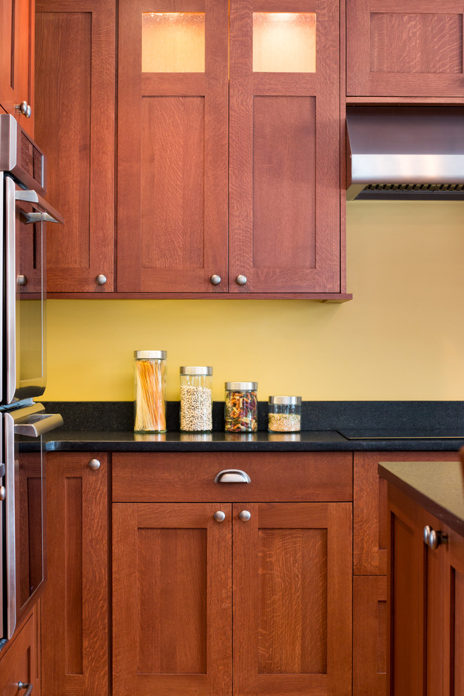 デトロイトにあるラグジュアリーな広いトラディショナルスタイルのおしゃれなキッチン (エプロンフロントシンク、フラットパネル扉のキャビネット、中間色木目調キャビネット、御影石カウンター、黄色いキッチンパネル、シルバーの調理設備、淡色無垢フローリング) の写真