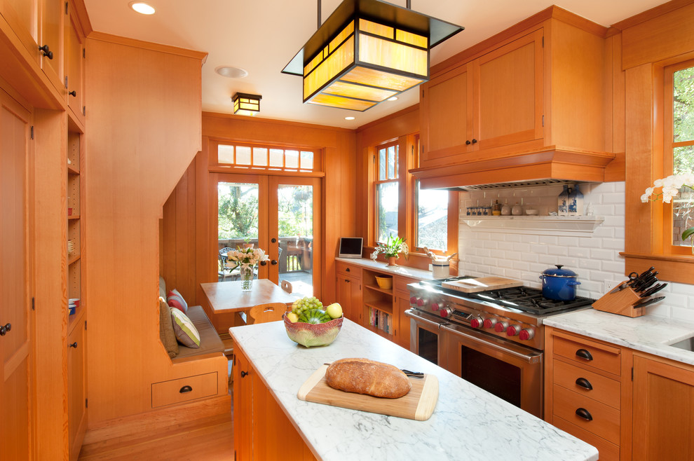 Example of an arts and crafts u-shaped enclosed kitchen design in San Francisco with an undermount sink, recessed-panel cabinets, light wood cabinets, marble countertops, white backsplash, ceramic backsplash and stainless steel appliances