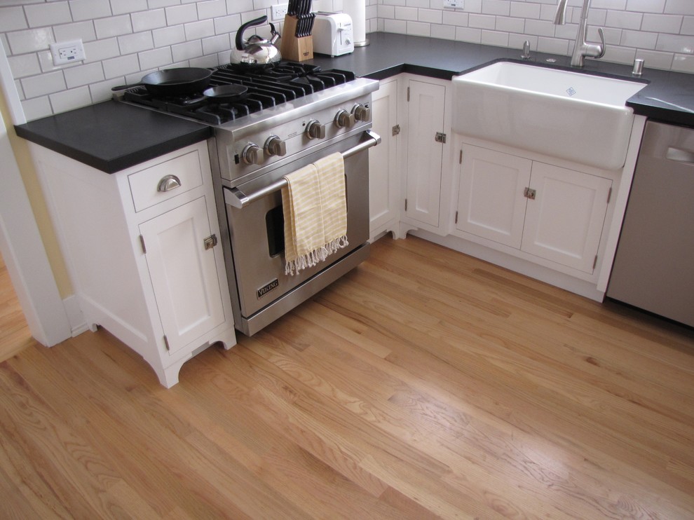 Bild på ett mellanstort lantligt l-kök, med en rustik diskho, skåp i shakerstil, vita skåp, bänkskiva i koppar, vitt stänkskydd, stänkskydd i keramik, rostfria vitvaror och ljust trägolv
