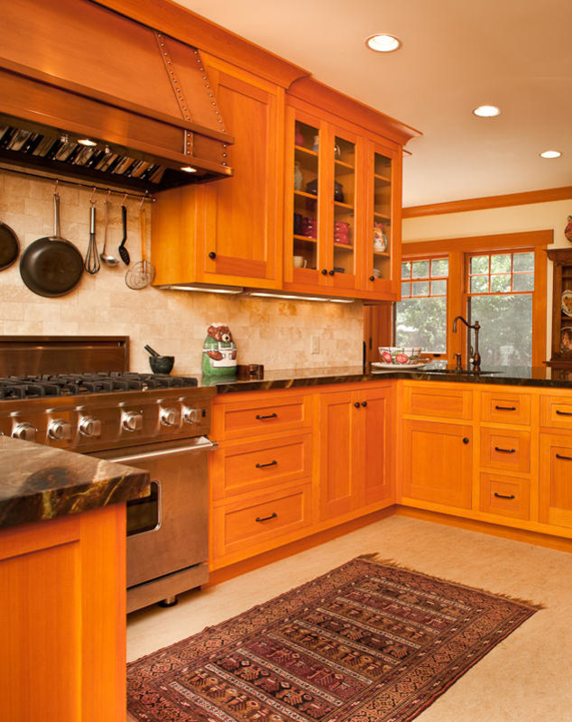 Photo of a large traditional l-shaped kitchen/diner in Santa Barbara with a built-in sink, recessed-panel cabinets, medium wood cabinets, laminate countertops, beige splashback, stone tiled splashback, stainless steel appliances, ceramic flooring, a breakfast bar and beige floors.