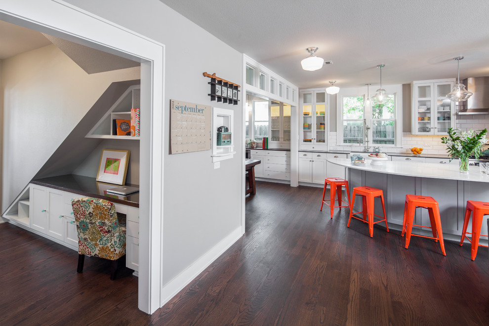 Photo of a medium sized classic l-shaped kitchen in Austin with a submerged sink, glass-front cabinets, white cabinets, engineered stone countertops, white splashback, stainless steel appliances, medium hardwood flooring and an island.