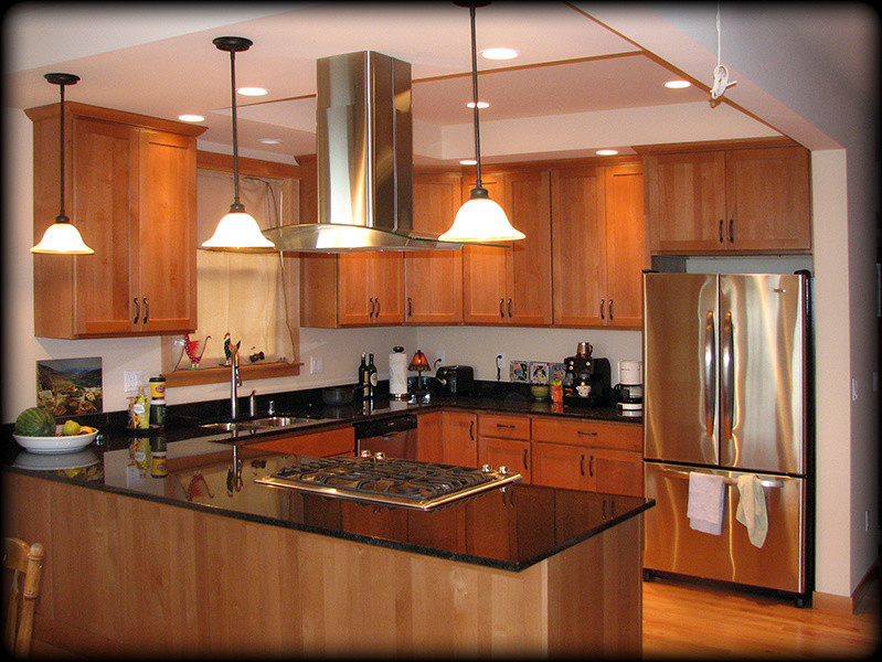 Foto di una cucina stile americano di medie dimensioni con ante in stile shaker, ante in legno scuro, top in granito, paraspruzzi nero, elettrodomestici in acciaio inossidabile, pavimento in legno massello medio e penisola