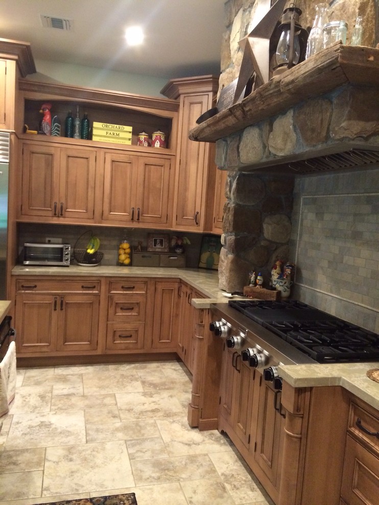 Bild på ett stort amerikanskt kök och matrum, med en enkel diskho, luckor med infälld panel, bruna skåp, bänkskiva i betong, grått stänkskydd, stänkskydd i tunnelbanekakel, rostfria vitvaror, klinkergolv i porslin och en köksö