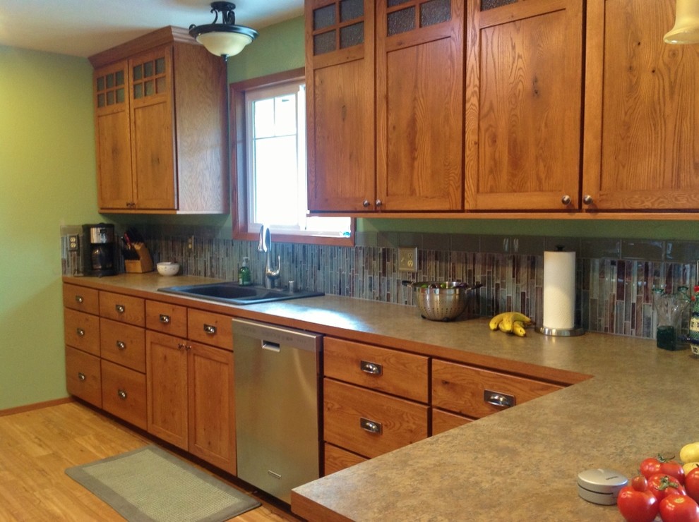 Foto på ett mellanstort amerikanskt kök och matrum, med skåp i shakerstil, skåp i mellenmörkt trä, laminatbänkskiva, flerfärgad stänkskydd, stänkskydd i glaskakel, rostfria vitvaror, mellanmörkt trägolv och en halv köksö