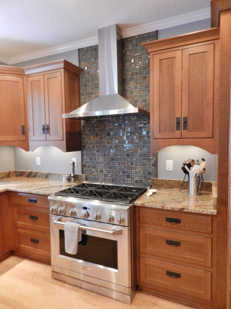 Mid-sized arts and crafts u-shaped light wood floor eat-in kitchen photo in Jacksonville with an undermount sink, shaker cabinets, medium tone wood cabinets, granite countertops, multicolored backsplash, mosaic tile backsplash and stainless steel appliances