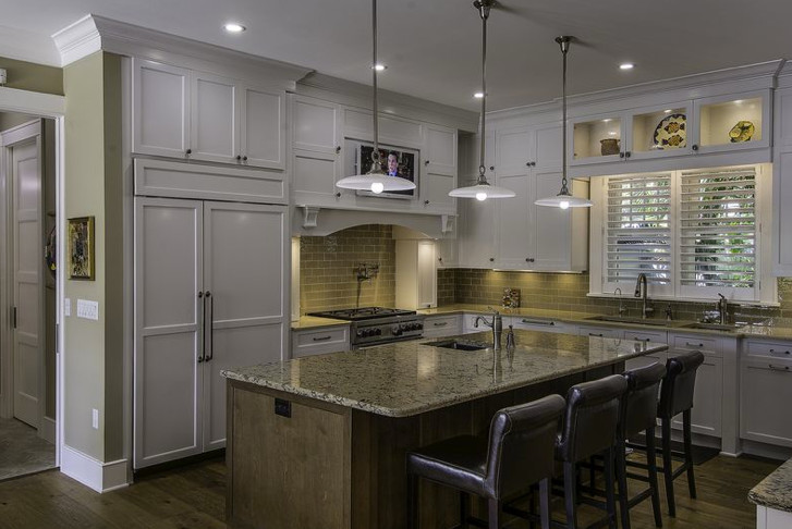 Photo of a large traditional u-shaped kitchen/diner in Tampa with a submerged sink, shaker cabinets, white cabinets, granite worktops, brown splashback, glass tiled splashback, stainless steel appliances, dark hardwood flooring, an island, brown floors and beige worktops.
