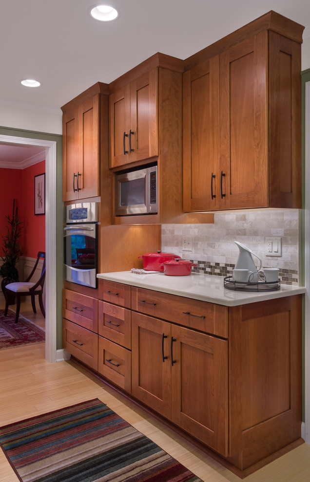 Inspiration for a large traditional kitchen in Detroit with shaker cabinets, medium wood cabinets, quartz worktops, beige splashback, stone tiled splashback, stainless steel appliances and bamboo flooring.