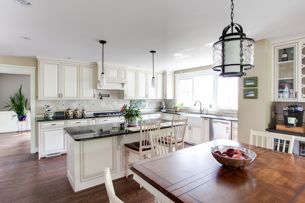 Eat-in kitchen - large traditional eat-in kitchen idea in DC Metro with a farmhouse sink, raised-panel cabinets, white backsplash, stainless steel appliances and granite countertops