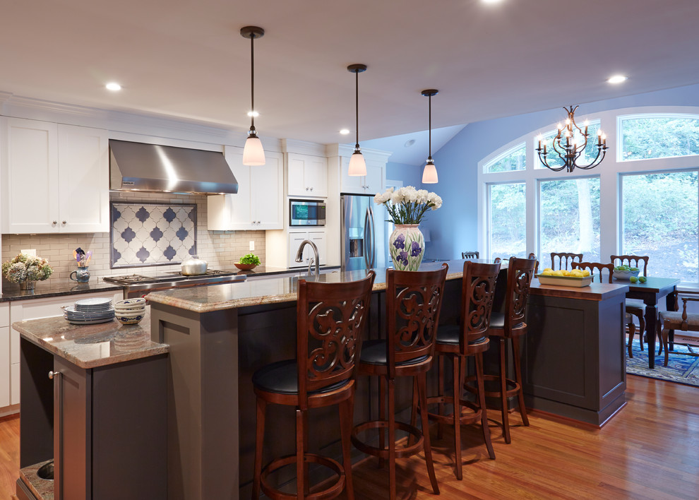 Inspiration for a large transitional medium tone wood floor eat-in kitchen remodel in DC Metro with an undermount sink, recessed-panel cabinets, white cabinets, granite countertops, white backsplash, subway tile backsplash, stainless steel appliances and an island