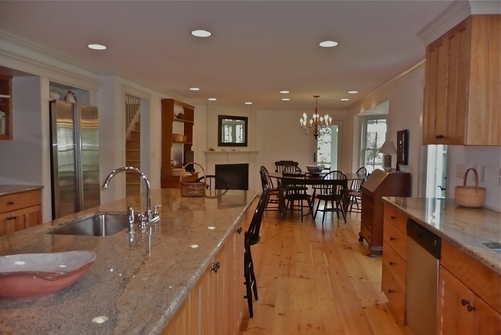This is an example of a large classic kitchen/diner in Boston with a submerged sink, shaker cabinets, medium wood cabinets, stainless steel appliances, an island, brown floors and medium hardwood flooring.