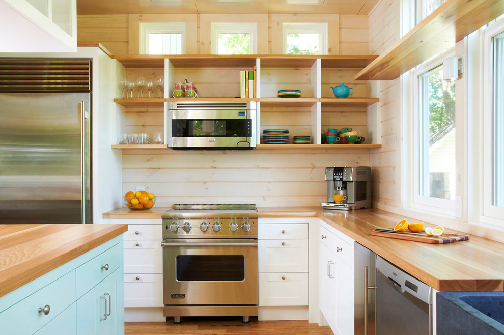 На фото: кухня в стиле модернизм с техникой из нержавеющей стали, деревянной столешницей, открытыми фасадами, светлыми деревянными фасадами и окном с