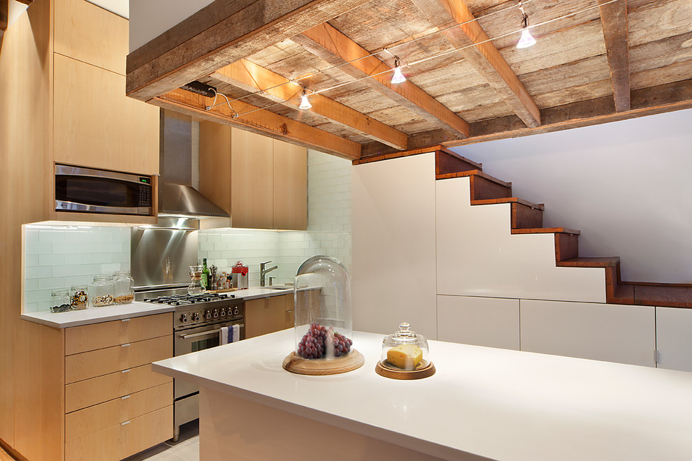 Eat-in kitchen - mid-sized industrial l-shaped ceramic tile eat-in kitchen idea in New York with an undermount sink, flat-panel cabinets, medium tone wood cabinets, granite countertops, glass tile backsplash, stainless steel appliances and an island