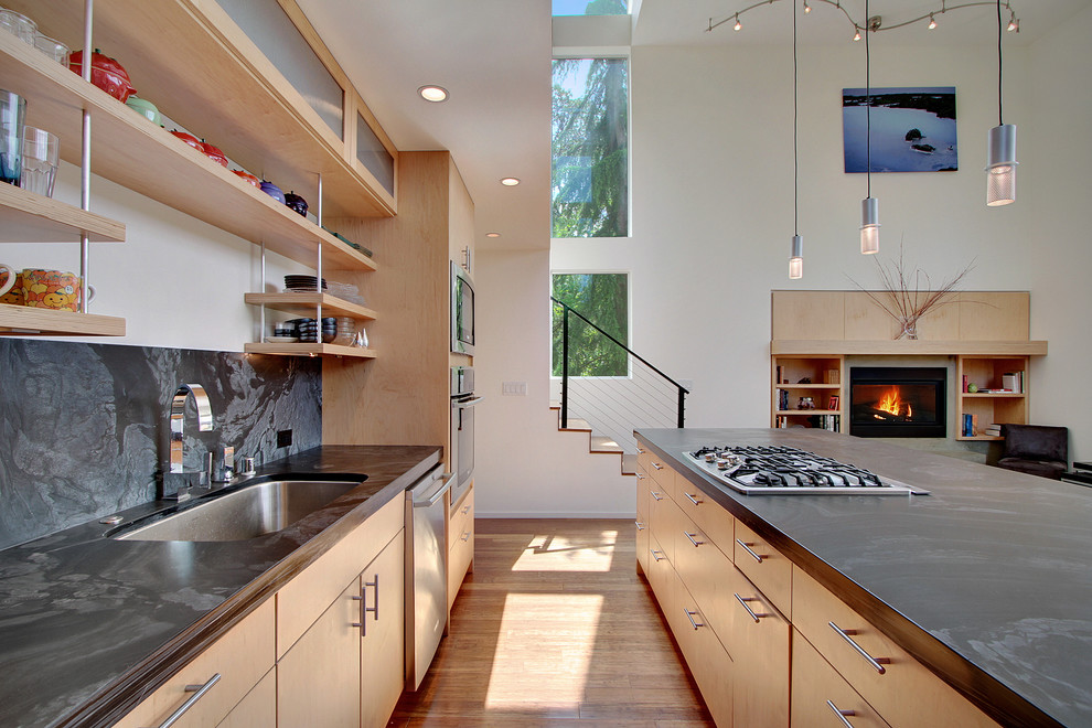 Offene Moderne Küche mit Waschbecken, offenen Schränken, hellen Holzschränken, Küchenrückwand in Schwarz, Rückwand aus Stein und Küchengeräten aus Edelstahl in Seattle