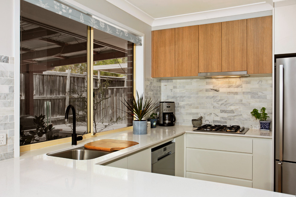 Inspiration for a medium sized contemporary u-shaped kitchen pantry in Sydney with a submerged sink, flat-panel cabinets, white cabinets, engineered stone countertops, grey splashback, metro tiled splashback, stainless steel appliances, medium hardwood flooring, a breakfast bar and yellow floors.