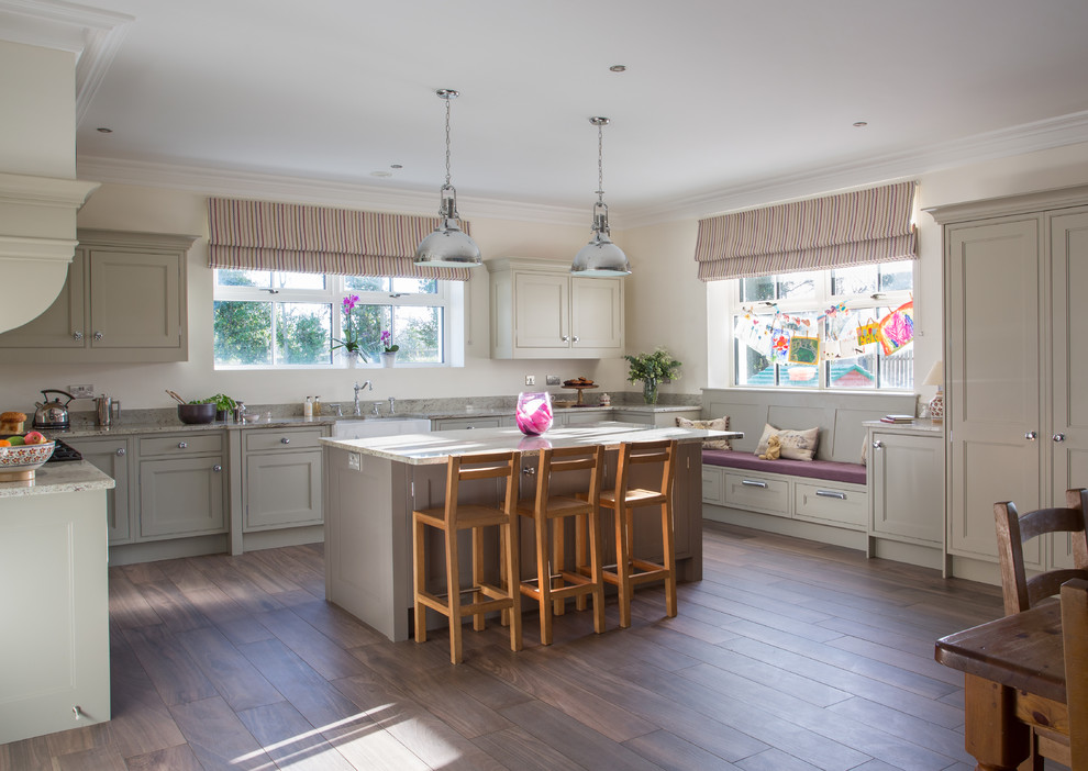 This is an example of a large country u-shaped open plan kitchen in Belfast with a belfast sink, shaker cabinets, granite worktops, dark hardwood flooring and an island.