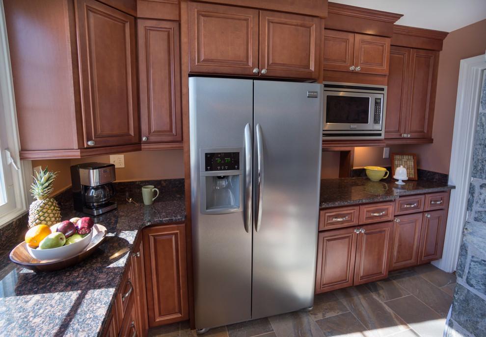 Eat-in kitchen - large traditional l-shaped porcelain tile eat-in kitchen idea in Providence with an undermount sink, raised-panel cabinets, medium tone wood cabinets, granite countertops, stone slab backsplash, stainless steel appliances and no island
