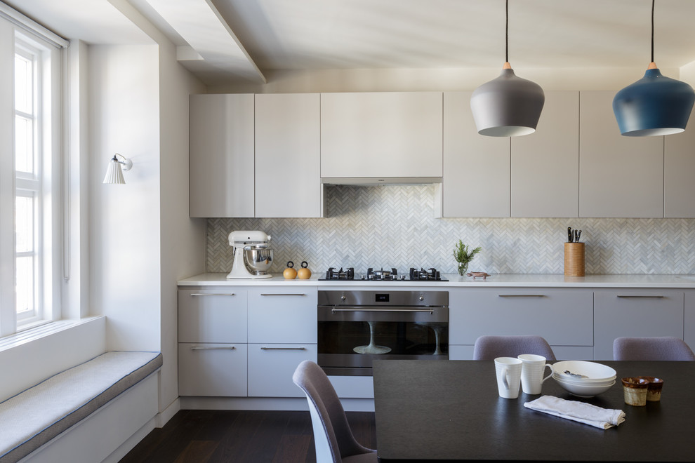 Esempio di una cucina lineare design di medie dimensioni con ante lisce, ante grigie, paraspruzzi grigio, parquet scuro e pavimento marrone