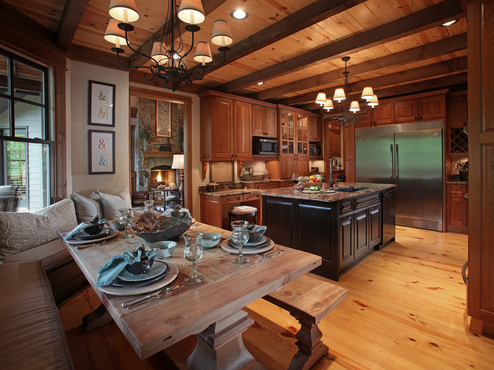 Example of a large classic u-shaped eat-in kitchen design in Atlanta with stainless steel appliances, an undermount sink, raised-panel cabinets, medium tone wood cabinets, granite countertops, beige backsplash and an island