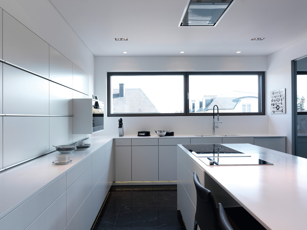 На фото: угловая кухня в стиле модернизм с плоскими фасадами, белыми фасадами и островом с