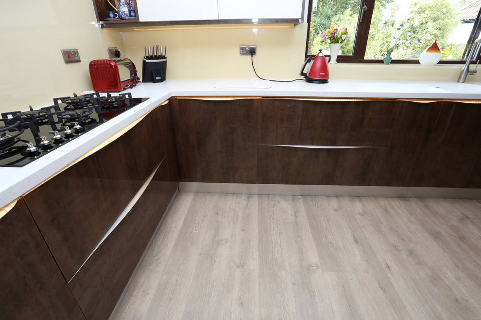 Immagine di una grande cucina design con lavello integrato, ante lisce, ante marroni, top in superficie solida e top bianco