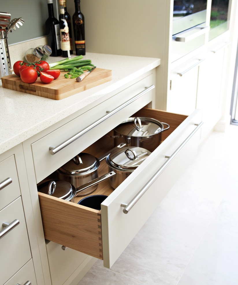 Imagen de cocina comedor contemporánea de tamaño medio con armarios con paneles empotrados, puertas de armario de madera clara, encimera de cuarcita y una isla