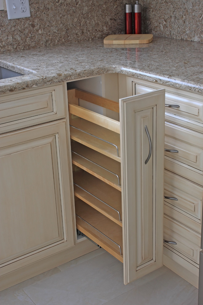 Klassisk inredning av ett mellanstort kök, med en undermonterad diskho, bänkskiva i kvarts, rostfria vitvaror, en köksö, luckor med upphöjd panel, beige skåp, beige stänkskydd, linoleumgolv och vitt golv
