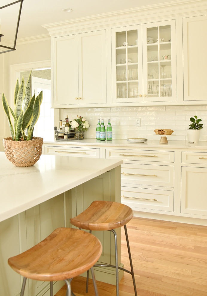 Inspiration för ett vintage vit vitt kök, med en rustik diskho, luckor med infälld panel, bänkskiva i kvarts, vitt stänkskydd, stänkskydd i keramik, ljust trägolv och en köksö