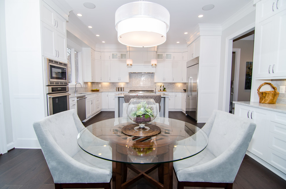 Eat-in kitchen - transitional u-shaped dark wood floor eat-in kitchen idea in DC Metro with an undermount sink, shaker cabinets, white cabinets, marble countertops, white backsplash, stone tile backsplash, stainless steel appliances and an island
